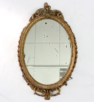 Lot 559 - An oval wall mirror in a gilt plaster frame...