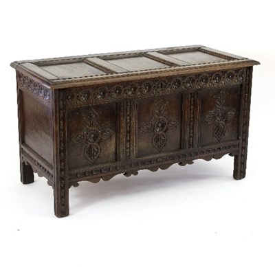 Lot 607 - An oak chest with triple-panel top and carved...