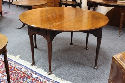 Lot 619 - A George III mahogany oval two-flap table, on...