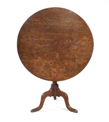 Lot 647 - An oak tilt-top table, the circular top on a...