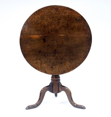 Lot 650 - A George III elm tilt-top table, the circular...