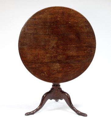 Lot 651 - A George III oak tilt-top table, the circular...