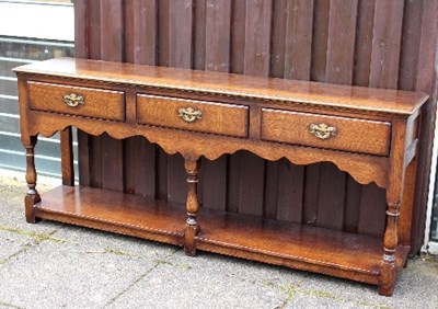 Lot 669 - An oak dresser base fitted three drawers, on...