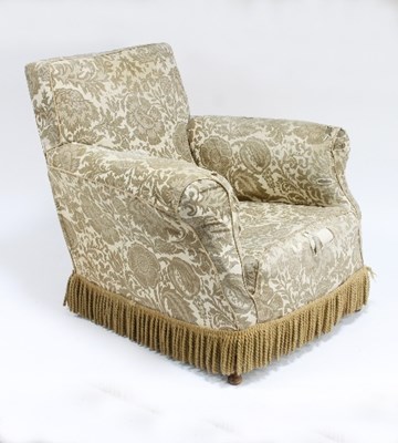 Lot 693 - An upholstered armchair with fringed cover