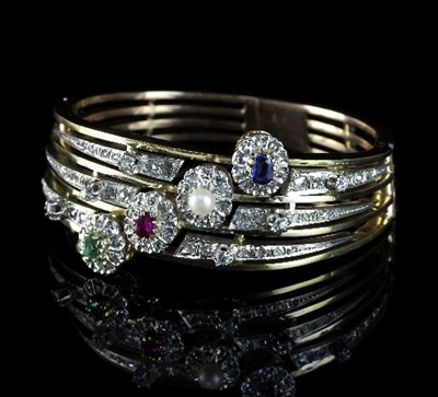 Lot 247 - A multi-gem set hinged bangle, the four knife...