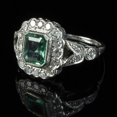 Lot 254 - A Colombian emerald and diamond cluster ring,...