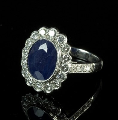 Lot 257 - A sapphire and diamond cluster ring, the oval...