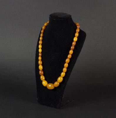 Lot 295 - A single row of thirty-six butterscotch amber...