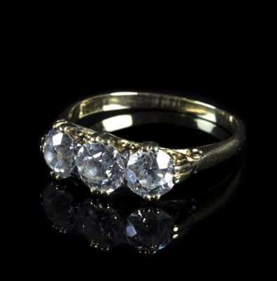 Lot 306 - A three-stone diamond ring in a scroll setting,...