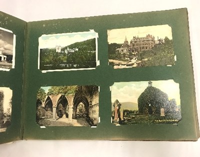 Lot 24 - Three albums of mainly topographical postcards,...