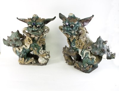 Lot 696 - A pair of Chinese pottery dogs of Fo in green,...