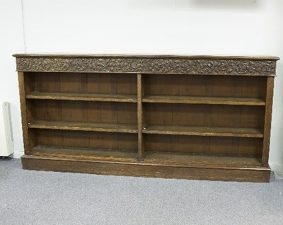 Lot 762 - A large oak bookcase, the frieze carved...