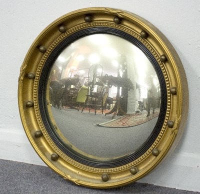 Lot 847 - A convex wall mirror with gilt surround and...