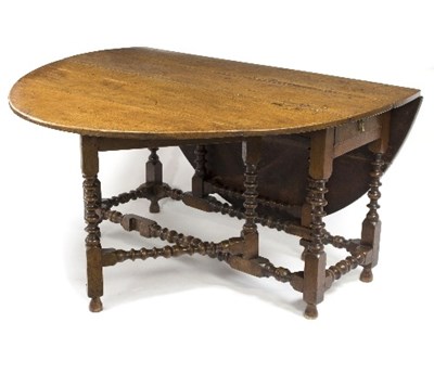 Lot 900 - An 18th Century oak two-flap table, on bobbin...