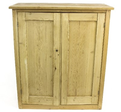 Lot 989 - A pine cupboard enclosed by panel doors, 107cm...