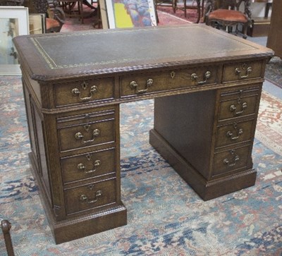 Lot 1083 - A George III style oak kneehole pedestal desk,...