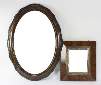 Lot 1091 - An oval mirror with wavy ripple moulded border,...