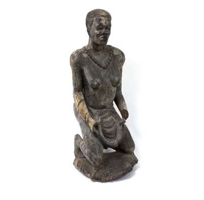 Lot 1285 - A carved African figure of a kneeling woman,...