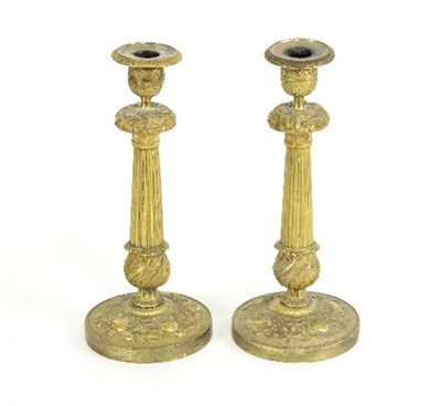 Lot 1317 - A pair of gilt metal candlesticks, each of...