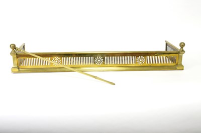 Lot 440 - A pierced brass fender and a brass fire poker