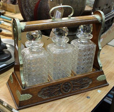 Lot 458A - A carved oak tantalus fitted three cut glass...