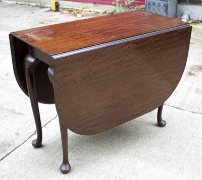 Lot 555 - A mahogany oval drop leaf table, on cabriole...