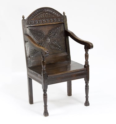 Lot 771 - A carved oak wainscot chair, the arched panel...