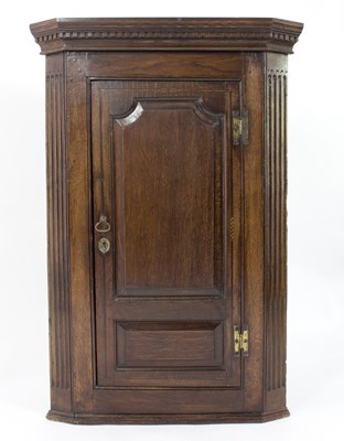 Lot 787 - A George III oak corner cupboard with dentil...