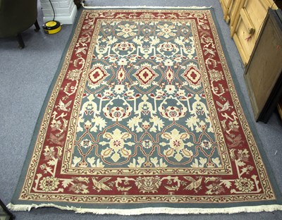 Lot 860 - A modern rug with stylised designs on a blue...