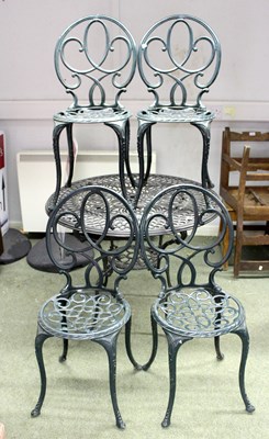 Lot 575 - A cast iron garden table and four chairs