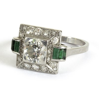 Lot 1141 - An Art Deco diamond and emerald ring centred...