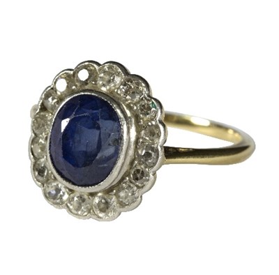 Lot 14 - A sapphire and diamond cluster ring, the oval...