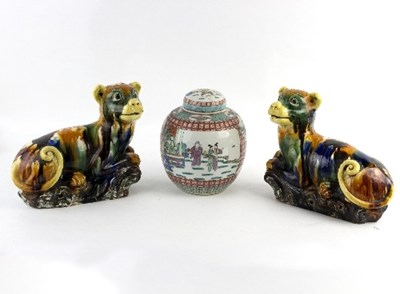 Lot 242 - A pair of Chinese pottery recumbent dogs, in...