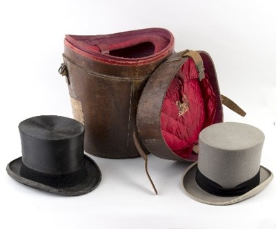 Lot 280 - Two Lock & Co. top hats in a brown leather hat...