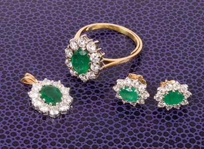 Lot 101 - An 18ct yellow gold emerald and diamond oval cluster ring