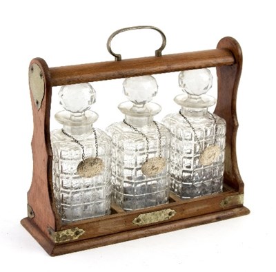 Lot 340 - An oak cased tantalus fitted three cut glass...