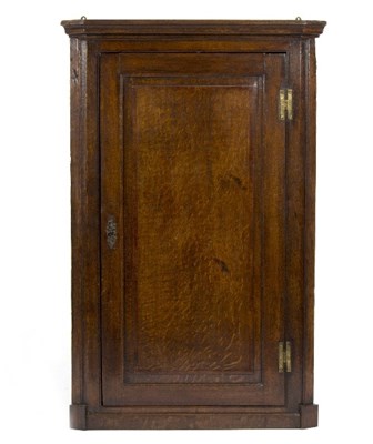 Lot 973 - A George III oak hanging corner cupboard, with...