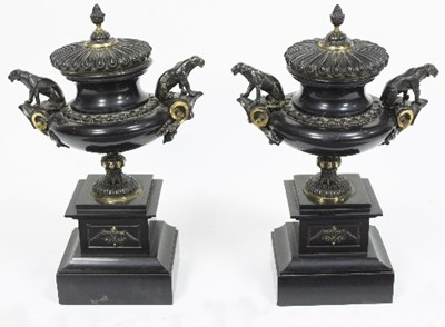 Lot 1178 - A pair of bronze urns with pine cone finials...