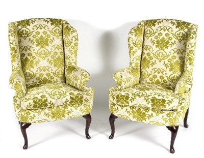Lot 64 - A pair of wing back armchairs upholstered in...