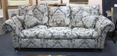 Lot 65 - A three-seater sofa upholstered in grey...