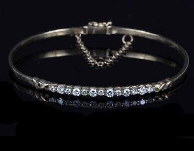 Lot 561 - A diamond set bangle, the thirteen round...