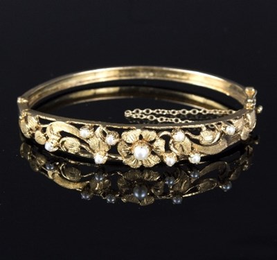 Lot 566 - A 9ct gold bangle with pierced foliate...