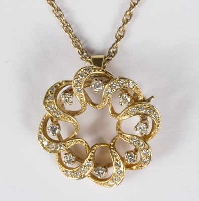 Lot 569 - A diamond pendant/brooch of circular pierced...