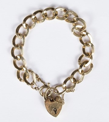 Lot 591 - A 9ct gold link bracelet with heart locket...