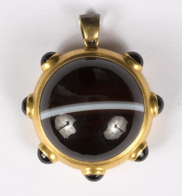 Lot 597 - A banded agate pendant of circular form, with...