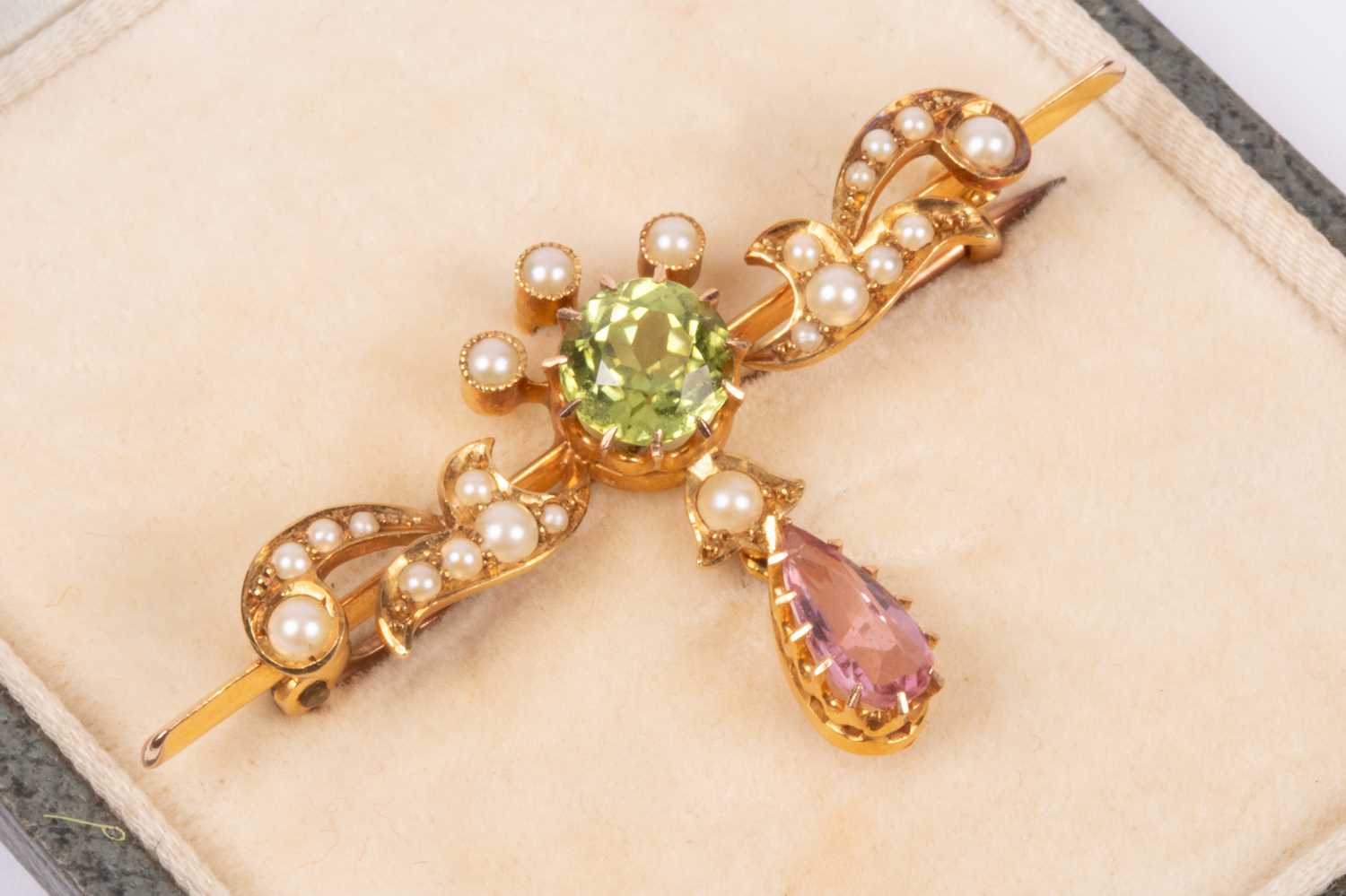 Lot 120 - An Edwardian Suffragette style 15ct yellow gold peridot, pink tourmaline and seed pearl bar brooch