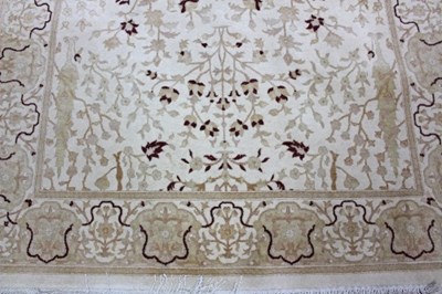 Lot 807 - A cream ground rug, Tree of Life design within...