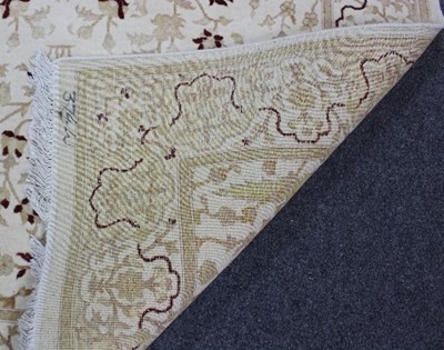 Lot 807 - A cream ground rug, Tree of Life design within...