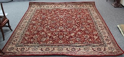 Lot 808 - A machine made floral carpet with red ground...