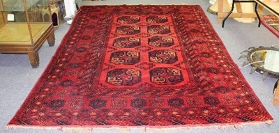 Lot 809 - An Afghan red ground carpet, the central field...